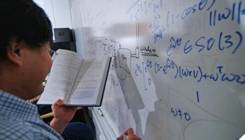 photo of student writing equation on board